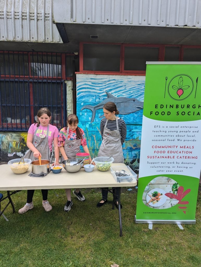 Three people serving food from a table.